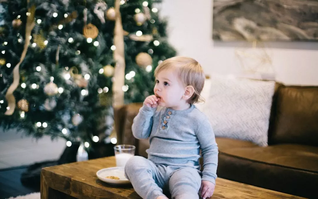 toddler infront of a christmas tree